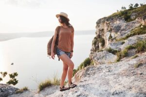 young-girl-with-backpack-enjoying-sunset-on-peak-o-QQPSQJN.jpg